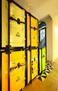 a row of yellow lockers in a room with checkered floors at ACE Hostel in Hanoi +21 photos