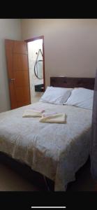 サン・フランシスコ・デ・イタバポアナにあるPousada Casa da Praia SFIのベッドとタオル2枚のある寝室