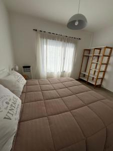 a bedroom with a large bed and a window at La Elenita Tandil in Tandil