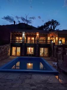 a house with a swimming pool in front of it at El Refugio de Coquena in Purmamarca