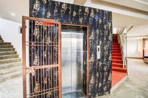 Un vestíbulo con una puerta de cristal y escaleras. en Collection O Infocity Metro Station Gandhinagar Formerly Hotel LLP, en Gandhinagar