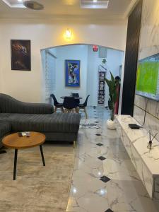a living room with couches and a flat screen tv at KC Shortlet in Asaba