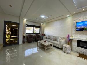 a living room with a couch and a fireplace at Chalet villa QUE POUR LES FAMILLES in Imouzzer Kandar