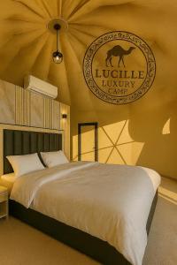 a bedroom with a bed and a sign on the wall at RUM LUCILLE lUXURY CAMP in Wadi Rum