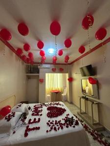 a room with a bed with red balloons on the ceiling at Hotel Arena Caliente in Playas