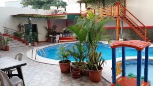 a swimming pool with plants next to a house at Hotel Arena Caliente in Playas