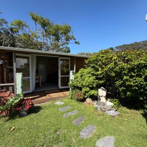 a house with a garden and a pathway at Captains Quarters in Ohope Beach