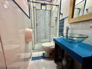 a bathroom with a glass sink and a toilet at Hotel Colibri Real in Filandia
