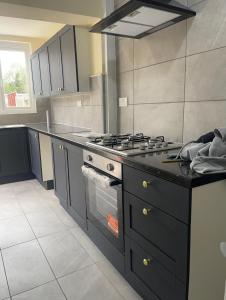 a kitchen with a stove top oven in a kitchen at Cheapest Sharing Room Dagenham East Station in Dagenham