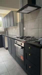 a kitchen with a stove top oven in a kitchen at Cheapest Sharing Room Dagenham East Station in Dagenham
