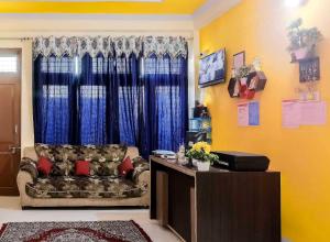 a living room with a couch and a window at Hotel O Prime Stayzz in Kaliānpur