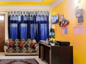 a living room with a couch and blue curtains at Hotel O Prime Stayzz in Kaliānpur
