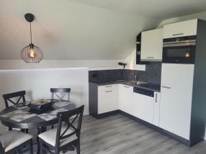 a kitchen with a table and a dining room at Le Pigeonnier in Dombresson +4 photos