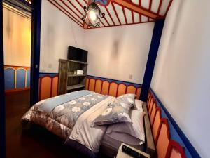 a bedroom with a bed with an orange head board at Hotel Colibri Real in Filandia