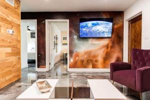 een woonkamer met een bank en een tv aan de muur bij 400 South - Unit A in Cocoa Beach