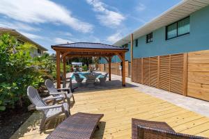 een houten terras met stoelen en een prieel bij 400 South - Unit A in Cocoa Beach