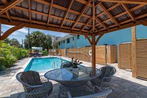 een terras met een tafel en stoelen en een zwembad bij 400 South - Unit B in Cocoa Beach