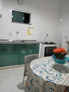 伊塔帕里卡岛维拉克鲁兹Casa de praia em Barra do Gil的厨房里摆放着一碗鲜花,桌子上放着一碗 更多26张照片