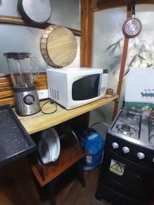 Chalé Bambu في كونها: وجود ميكروويف على طاولة بجوار موقد +33 صورة