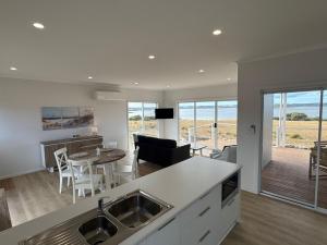 Pelican Lagoon Retreat في Pelican Lagoon: مطبخ وغرفة معيشة مطلة على المحيط +23 صورة