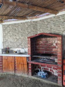 a kitchen with a brick fireplace with a sink at Villa Naylamp loft 10 beach pocitas in Puerto Máncora