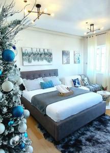 a bedroom with a bed and a christmas tree at The Lumiére Stays Sophisticated Escape Mallside Charm in Trece Martires