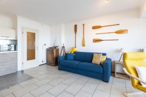 een woonkamer met een blauwe bank en een keuken bij Sun Beach 0201 in Sint-Idesbald