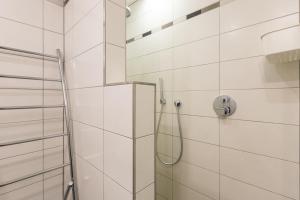 een douche in een badkamer met witte tegels bij Sun Beach 0201 in Sint-Idesbald +12 foto's