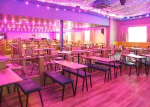 UlromeにあるUnity Skirlington Coast Yorkshireのダイニングルーム(テーブル、椅子、紫色の照明付)