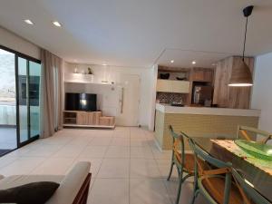 Parque das Ilhas • Resort Perto do Beach Park في Mangabeira: مطبخ وغرفة معيشة مع طاولة وكراسي