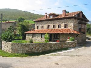 una antigua casa de piedra con una pared de piedra en Apartamentos Rurales Colsa, en Colsa