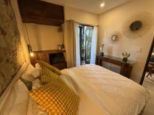 a bedroom with a bed with white sheets and yellow pillows at Firenze en ValQuirico in Santeagueda