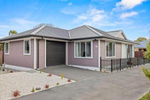 a pink house with a garage at City Fringe-Guest House in Christchurch