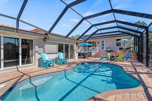 una piscina con sedie blu e un patio di Hidden Treasure - 622 a Bailey Hall