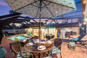 un patio con tavolo e sedie e una piscina di Hidden Treasure - 622 a Bailey Hall