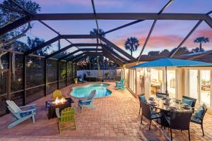 un patio con piscina, tavolo e sedie di Hidden Treasure - 622 a Bailey Hall