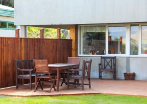 einen Holztisch und Stühle auf einer Terrasse in der Unterkunft Hestasport Apartment in Varmahlid