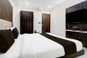 アーメダバードにあるSuper Hotel O Nana Chiloda Near Airport Formerly Green Valleyのベッドルーム(白い大型ベッド1台、薄型テレビ付)