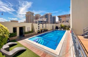 a swimming pool on the roof of a building at Cozy Cabin by JLS Near Venice Grand Canal Mall in Manila