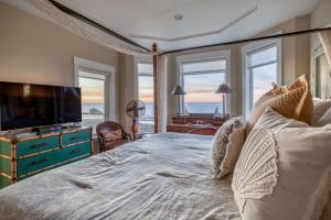 a bedroom with a bed with a television and windows at Sunsets at the Shoreline in Newport