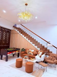 a living room with a staircase and a chandelier at Solia Villa in Da Nang +25 photos