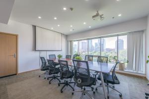 ein Konferenzraum mit einem langen Tisch und Stühlen in der Unterkunft Yasfield Hotel, Beijing Tuanjiehu Hujialou Subway Station Branch in Peking