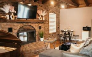 a living room with a brick fireplace with a flat screen tv at Couples Guesthouse, jacuzzi, sauna, pool in Merrillville