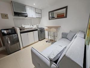 a living room with a couch and a kitchen at Aparta-estudio acogedor con balcón y parqueadero junto a la UPTC, Tunja in Tunja