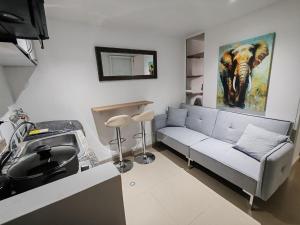 a living room with a couch and a painting of an elephant at Aparta-estudio acogedor con balcón y parqueadero junto a la UPTC, Tunja in Tunja