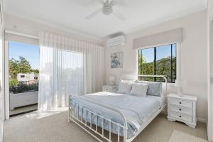 ein weißes Schlafzimmer mit einem Bett und einem großen Fenster in der Unterkunft Mountain Views Milton - renovated home near village in Milton