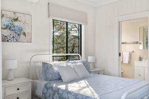 ein weißes Schlafzimmer mit einem Bett und einem Fenster in der Unterkunft Mountain Views Milton - renovated home near village in Milton