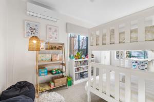 ein weißes Schlafzimmer mit einem Etagenbett und Regalen in der Unterkunft Mountain Views Milton - renovated home near village in Milton