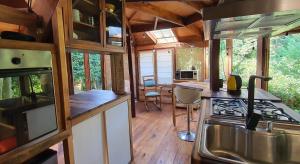 a kitchen and dining area of a tiny house at Octógono Soñado Lodge in El Boquerón