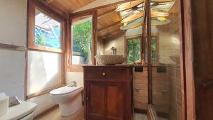 a bathroom with a toilet and a glass shower at Octógono Soñado Lodge in El Boquerón +3 photos